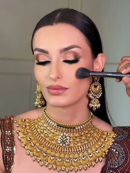 A behind-the-scenes shot of me applying blush. The eye makeup is a soft brown smokey look, which is a versatile style that I teach for both everyday wear and special occasions.