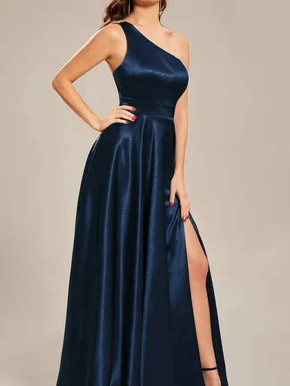 Another angle of the one-shoulder navy satin gown, highlighting the way the fabric catches the light and the flattering cut of the silhouette.