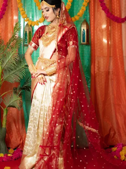 A full-length view of a model in a traditional South Indian bridal saree, complete with a temple jewellery set including a choker, haram, and kamarbandh (waist belt).