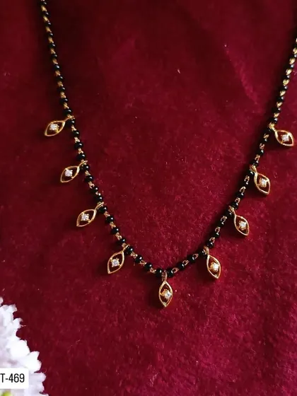 This delicate mangalsutra features small leaf-shaped charms along the chain. It's a nature-inspired design that is both modern and elegant.