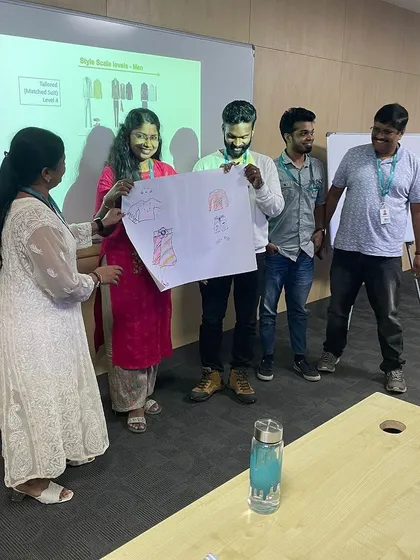 A team proudly presents their work during a styling activity. These collaborative moments are crucial for reinforcing learning and building team cohesion around the principles of professional image.