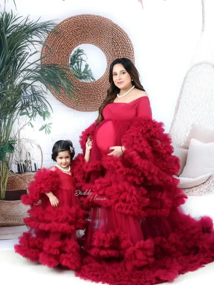 A beautiful maternity portrait of a mother and her daughter in matching ruffled red gowns from my luxury outfit collection. I love capturing the bond between family members as they await their new arrival.