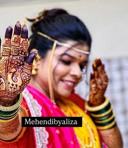 A happy bride showing off her dark stained henna. A beautiful smile and a beautiful stain, what more could an artist ask for?