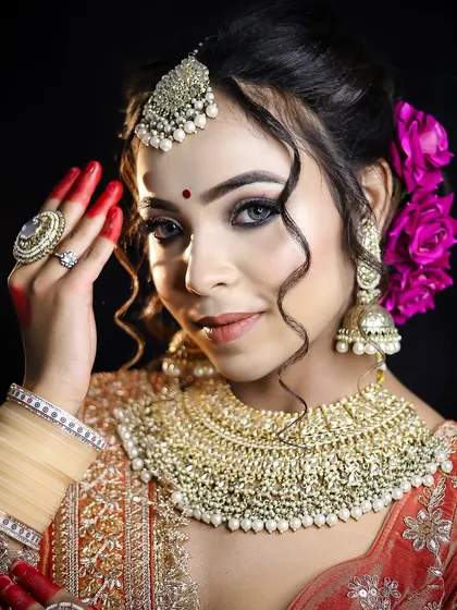 A traditional Bengali bridal look with alta-decorated hands and a striking bindi. I teach the cultural significance and artistic techniques behind these timeless looks.
