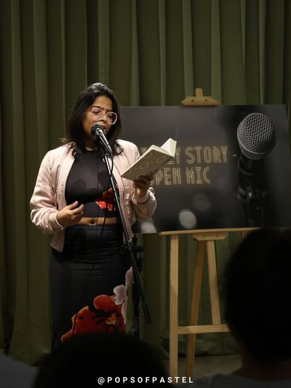 A poet reading from a book, sharing literary art with an engaged audience.
