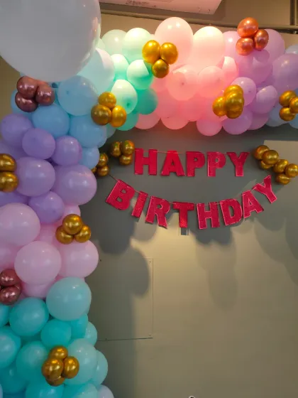 A simple and colorful basic balloon arch for a birthday. This pastel-colored arch with small gold balloon accents is a great way to add a festive touch above a doorway or against a wall.