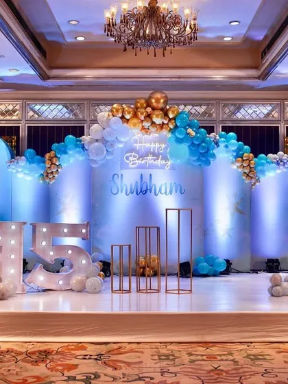 The blue and gold themed stage setup for a 15th birthday party.