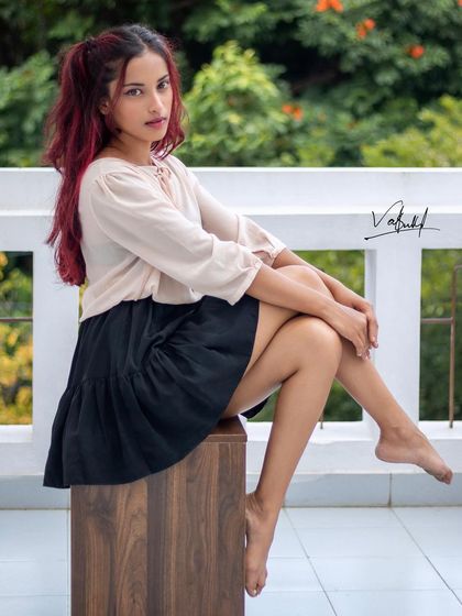 Attitude in the bones. This seated portrait captures a confident and stylish mood. The simple setting allows the model's personality and fashion sense to be the main focus of the shot.