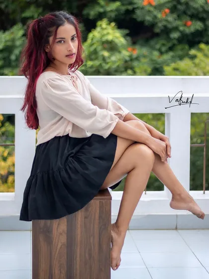 Attitude in the bones. This seated portrait captures a confident and stylish mood. The simple setting allows the model's personality and fashion sense to be the main focus of the shot.