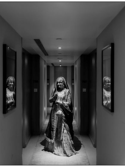A striking black and white portrait of the bride in a hotel corridor. The symmetry and reflections in the mirrors create a dramatic and memorable image.