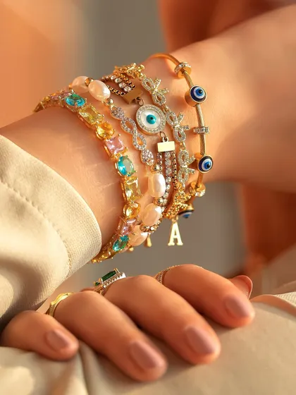 A close-up of one of my newest creations. This stack features a mix of colorful gemstones, pearls, and a personalized 'A' initial charm.