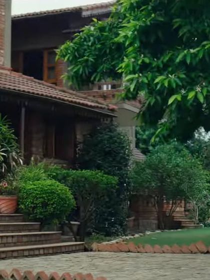 A wide shot showing the family at their beautiful home. The relaxed, earth-toned outfits I chose for them blend perfectly with the natural, upscale setting.