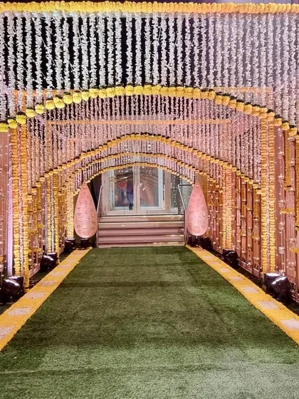 A beautiful entrance tunnel for a Haldi ceremony, created entirely with strings of marigold and white flowers. This floral passage creates an immersive and fragrant welcome for guests.