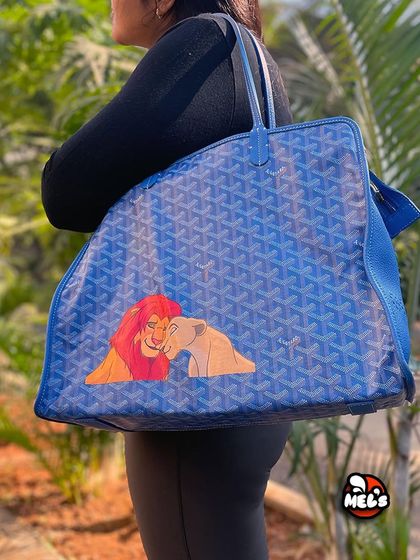 A model shot of the finished Lion King Goyard tote, showing how the custom artwork looks when the bag is carried.