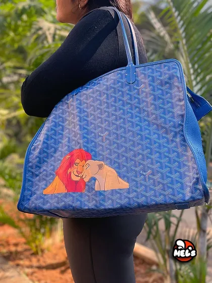 A model shot of the finished Lion King Goyard tote, showing how the custom artwork looks when the bag is carried.