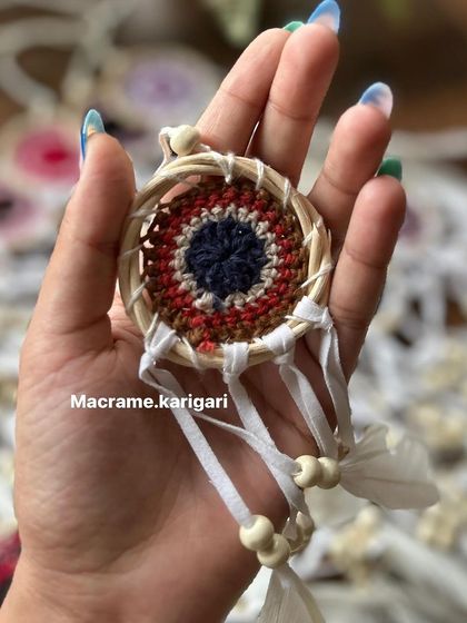 Holding one of our mini cane dreamcatchers. This one features an evil eye design, combining two powerful talismans for protection and good vibes.