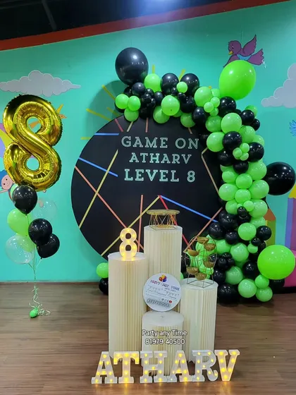 The main stage for the 'Game On' party, featuring a custom backdrop, a balloon garland, and light-up letters and numbers.