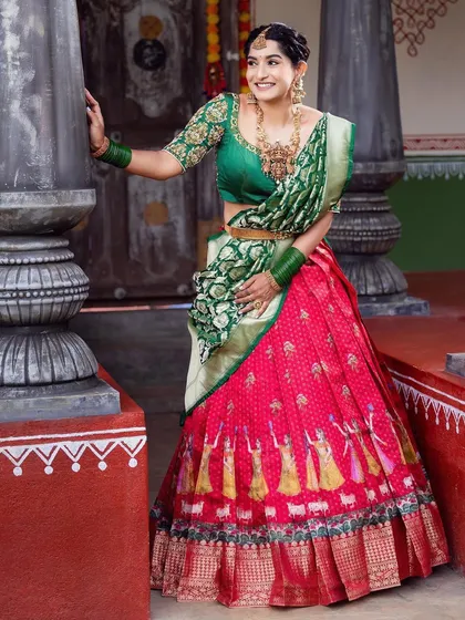 A timeless look for any traditional function. This classic silk Langa Voni, with its rich red skirt and contrasting green blouse and dupatta, is a favorite for festive events and family gatherings.