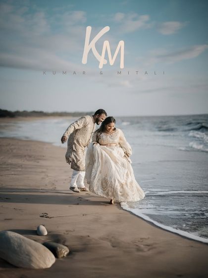 A playful moment captured as the couple walks along the beach, their traditional attire adding elegance to the natural setting.