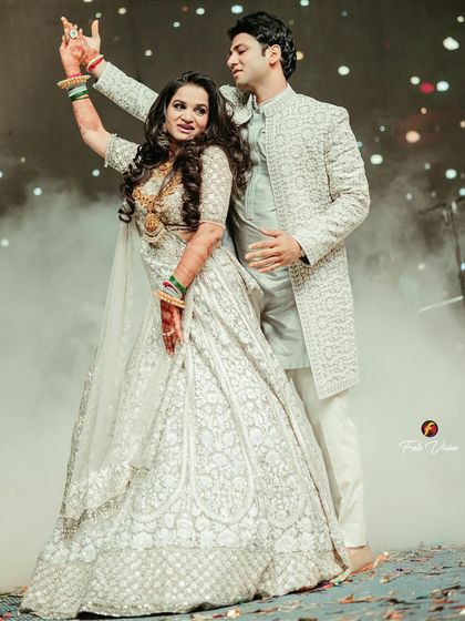 A dynamic shot of the couple's first dance. The movement in the bride's lehenga and the smoke filled stage create a dramatic and energetic image.