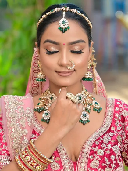 A close-up shot showing the beautiful winged eyeliner and soft glam makeup that complements the heavy bridal jewellery without competing with it.