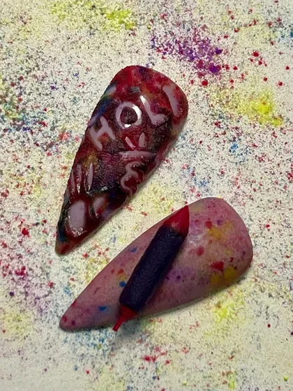 "Holi Hai!" This vibrant nail art captures the messy fun of Holi, featuring 3D elements like a pichkari and carved lettering.