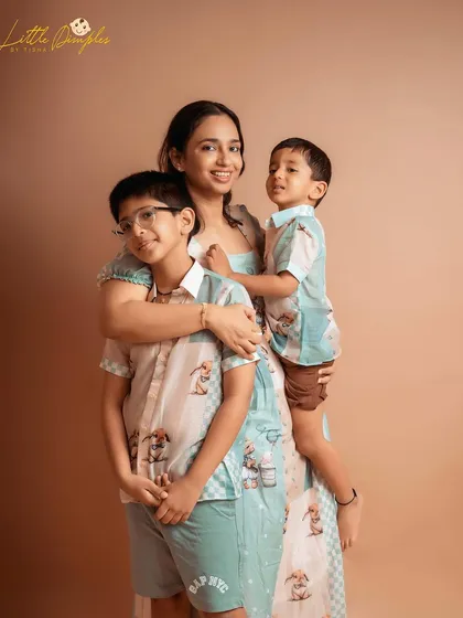 A beautiful portrait of a mother embracing her two sons. The coordinated outfits add a lovely touch to this heartwarming family photo.