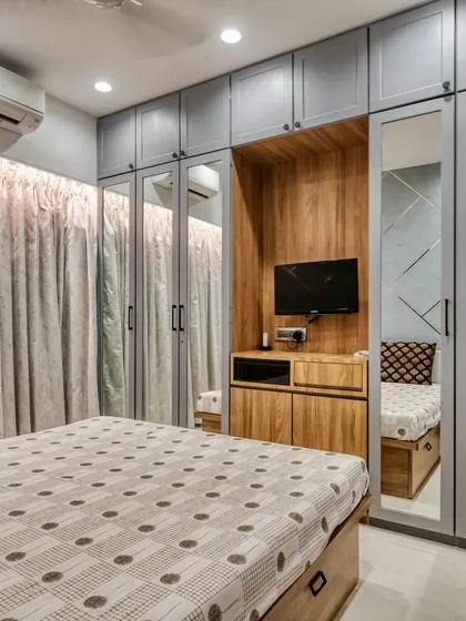 We make bedrooms amazing with cool interior designs. This space features a custom wardrobe with an integrated TV unit, combining storage and entertainment seamlessly.