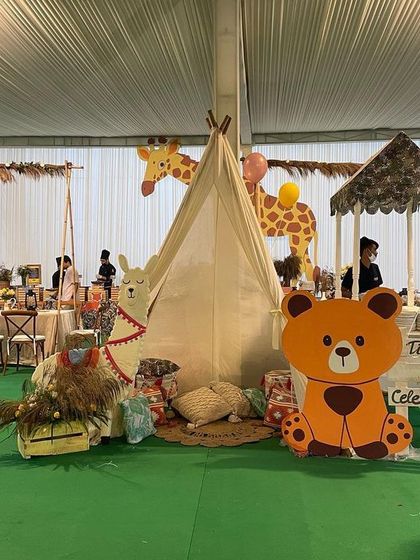 A teepee serves as a fun and cozy nook for the kids at the Boho Chic animal party, decorated with a bear cutout and rustic elements.
