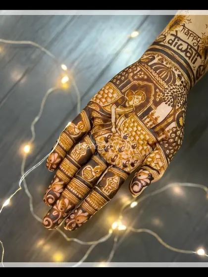 A festive Diwali-themed mehendi design. This intricate piece features a woman lighting diyas, with 'Happy Diwali' written on the wrist, capturing the spirit of the festival of lights.