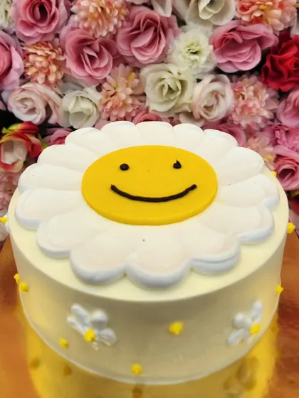 A cake that's guaranteed to make you smile. This cheerful daisy cake with a happy face center is a simple yet joyful design. It’s perfect for brightening up anyone's day, whether it's for a birthday or just because.