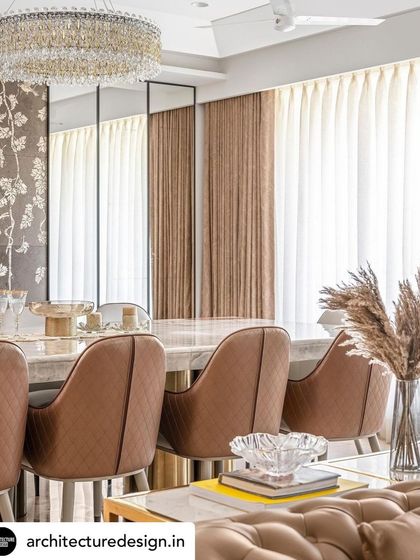The dining room is defined by quilted leather chairs and a grand crystal chandelier, reflecting our ability to source and integrate statement furniture and lighting to elevate a space.