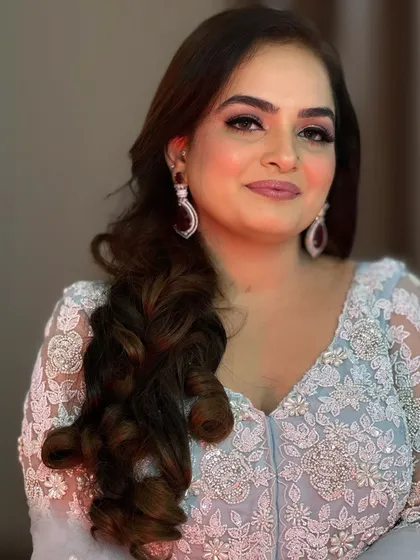 A close-up portrait showing a soft party makeup look. The focus is on a subtle pink and silver eye, rosy cheeks, and a soft pink lip, creating a very feminine and elegant style.