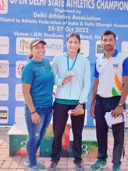 Posing with one of my dedicated athletes after her win. My role is to provide the plan and the push, but she earned this medal with her sweat.