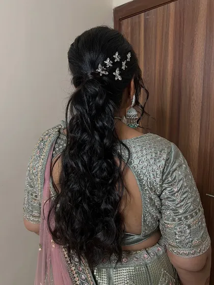 A voluminous ponytail with beautiful curls and butterfly accessories. This hairstyle is glamorous and perfect for making a statement at an evening event.
