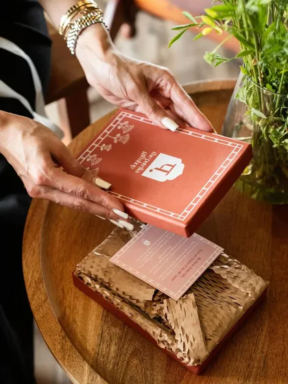 The simple act of unboxing a thoughtful gift. This lifestyle product shot for Patrika Gift Shop captures that intimate moment, showing how a product lives and breathes in the hands of the person it's meant for.