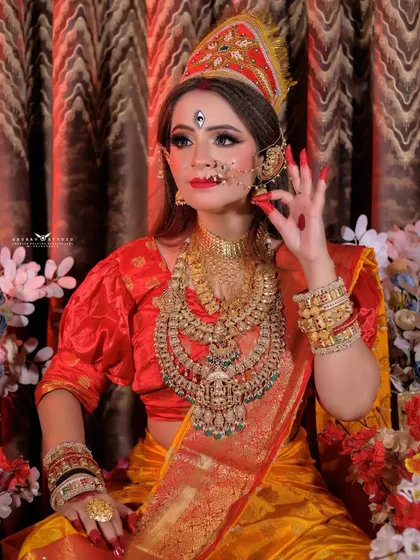A close-up on the model's expressive gesture and the traditional Bengali-style makeup.