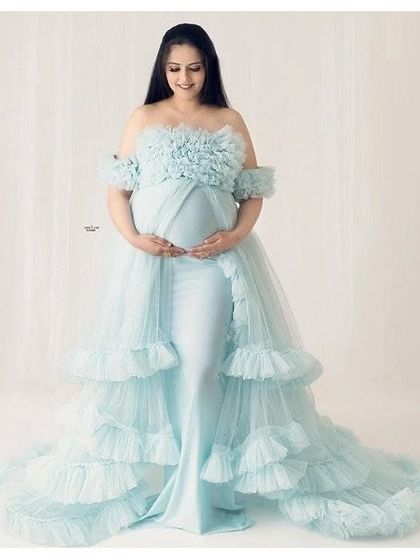 A classic studio portrait featuring our light blue ruffled gown. The clean background allows the intricate details and soft color of the dress to be the main focus.