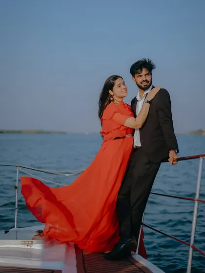 The wind catches the red gown perfectly in this dynamic shot. A yacht provides a fantastic location for capturing these kinds of effortlessly chic pre-wedding photos.