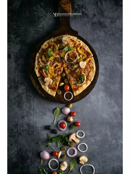 A rustic vegetable pizza, styled with its fresh ingredients cascading down the frame. This creative flatlay for Double Tree by Hilton tells the story of the pizza from ingredients to finished product.