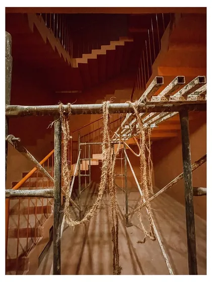 A view of the staircase during the evening, with scaffolding still in place, capturing a moment of transition from construction to completion.