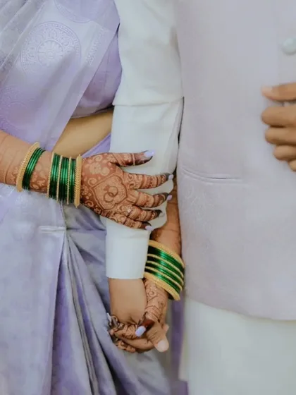 A romantic close-up of the couple holding hands, showing the bride's intricate engagement mehndi. It’s a beautiful symbol of their connection.