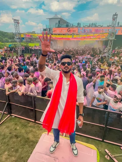 A photo from a Holi festival in 2023, with me waving to the pink-colored crowd. The energy of these events is unmatched.