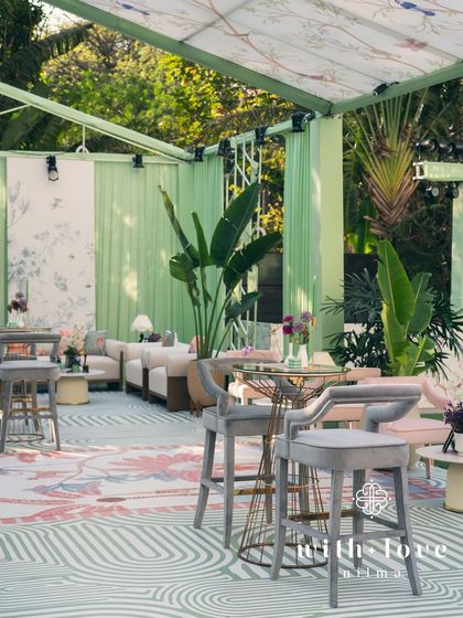 A wide view of 'The Conservatory' baby shower, showing the bar, lounge seating, and custom decor.