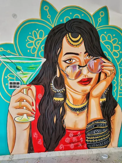 This pop art mural for Nueva Cafe features a modern desi woman with a martini. The bold colors, graphic style, and fusion of traditional jewelry with a contemporary vibe perfectly capture the cafe's energetic and stylish atmosphere.
