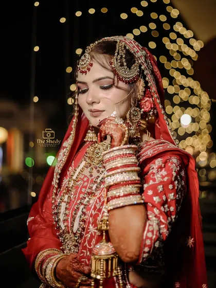 A beautiful portrait of bride Simran, highlighting her traditional jewelry and kaleeras. The pose is natural and elegant, showcasing the intricate details of her complete bridal look.