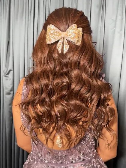 Another view of the beautiful bow hairstyle. The soft waves and sparkling accessory create a look that is both playful and sophisticated.