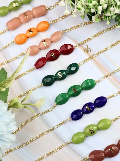 Our personalized Quartz Rakhi collection, featuring initials on colorful semi-precious stones. A stylish and meaningful way to celebrate your bond.