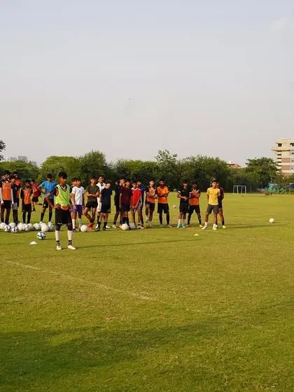 A coach addressing the team before starting a drill. Clear communication and instruction are central to our coaching.