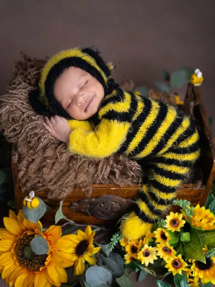 Look at that happy little bumblebee! This photo shows the playful side of my themed sessions. Using soft, baby-safe knit outfits and cheerful props like these sunflowers, I create vibrant and joyful scenes that reflect your baby's sunny personality.